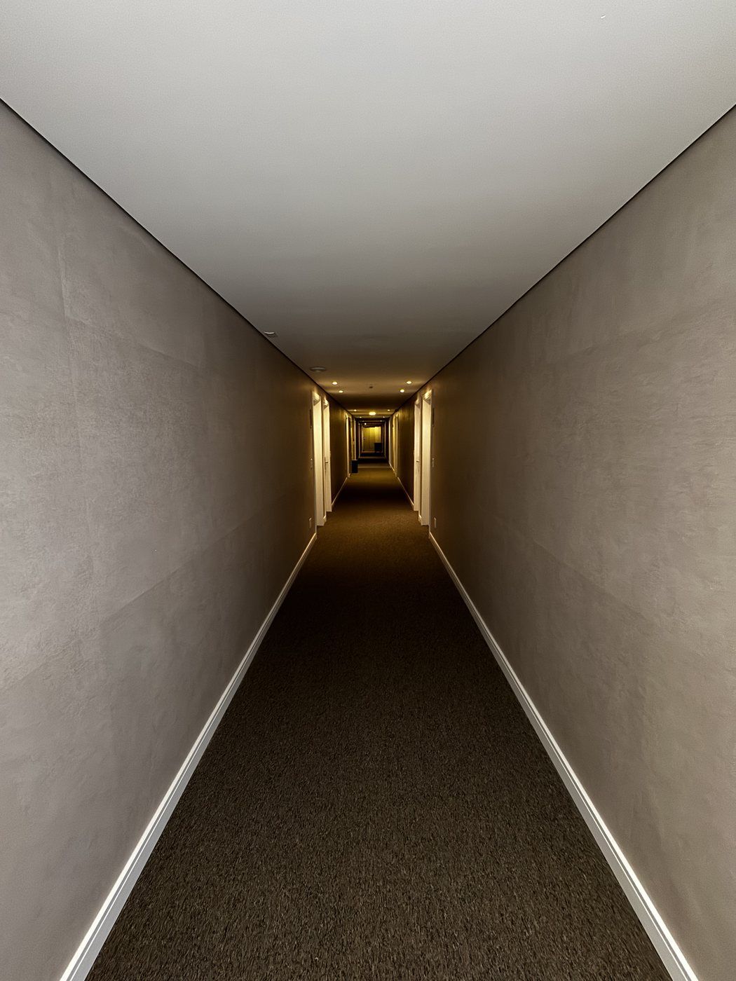 Corredor com carpete escuro e iluminação de LED embutida