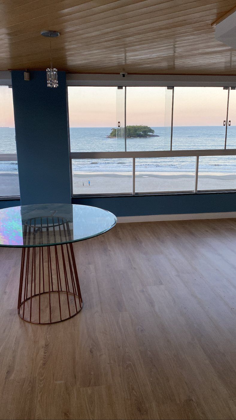 Piso laminado em sala ampla com vista para o mar