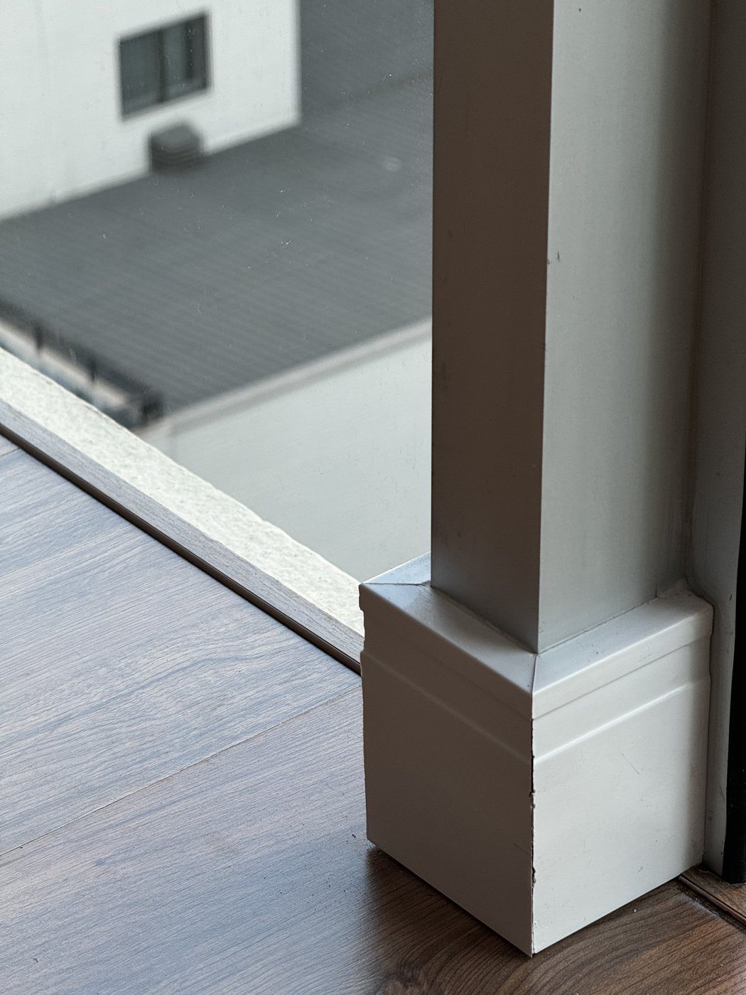 Piso laminado em ambiente amplo com coluna e janela