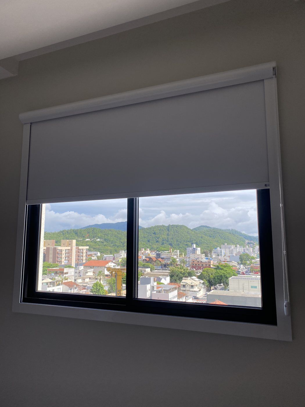 Persiana rolô blackout em janela com vista urbana